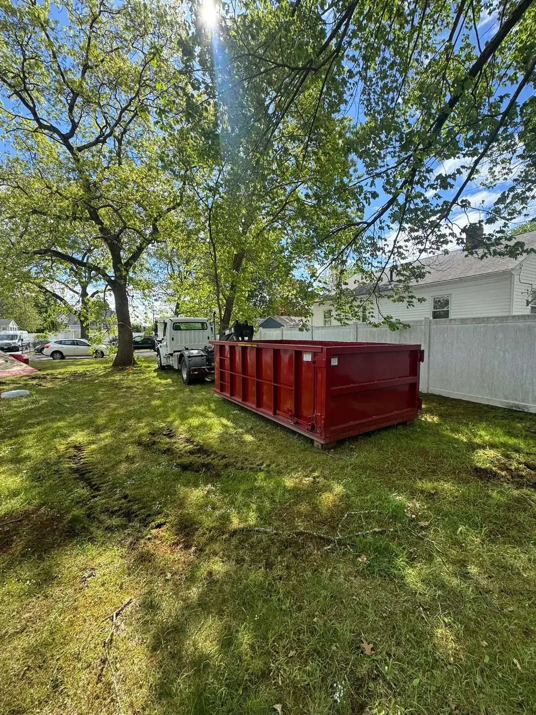 Red roll off dumpster positioned on a residential lawn for a yard project